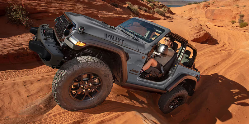 Jeep Wrangler navigating through rugged desert terrain